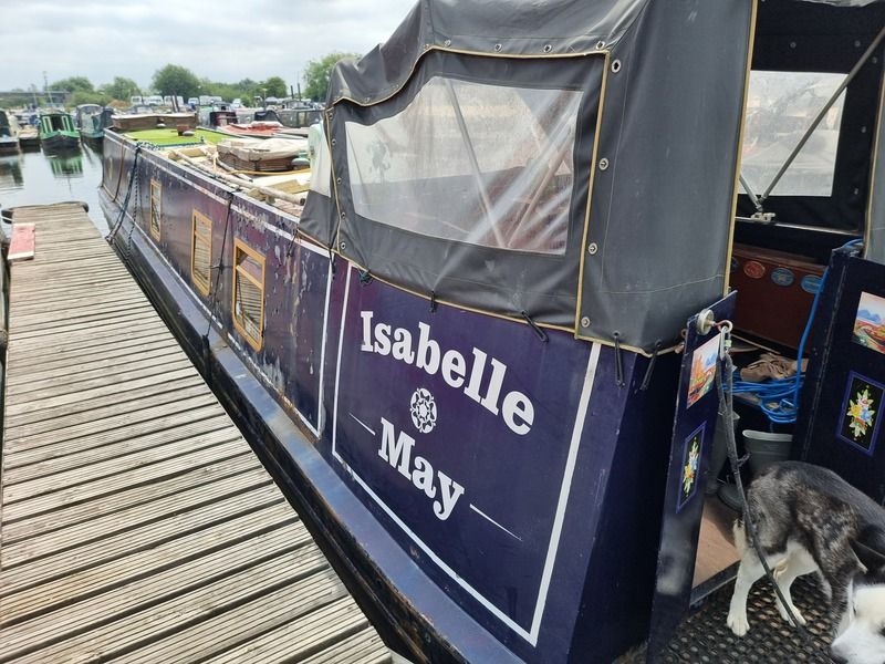 N G Moss 50ft Semi Trad called Isabelle May 50ft semi-traditional narrowboat "Isabelle May" docked, featuring a blue exterior and canopy.