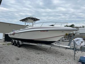 Fountain 31 Center Console 1998 Fountain 31 CC boat on trailer, parked outdoors under cloudy sky.