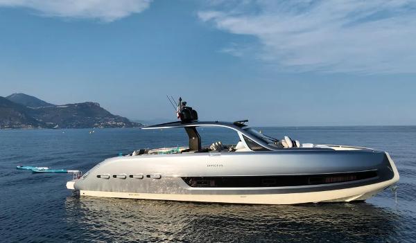 Invictus TT460 2023 Invictus TT460 yacht on calm sea with scenic mountain backdrop.