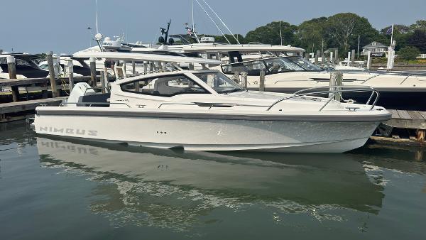 Nimbus W9 2024 Nimbus W9 boat docked at marina, sleek design, calm water reflection.