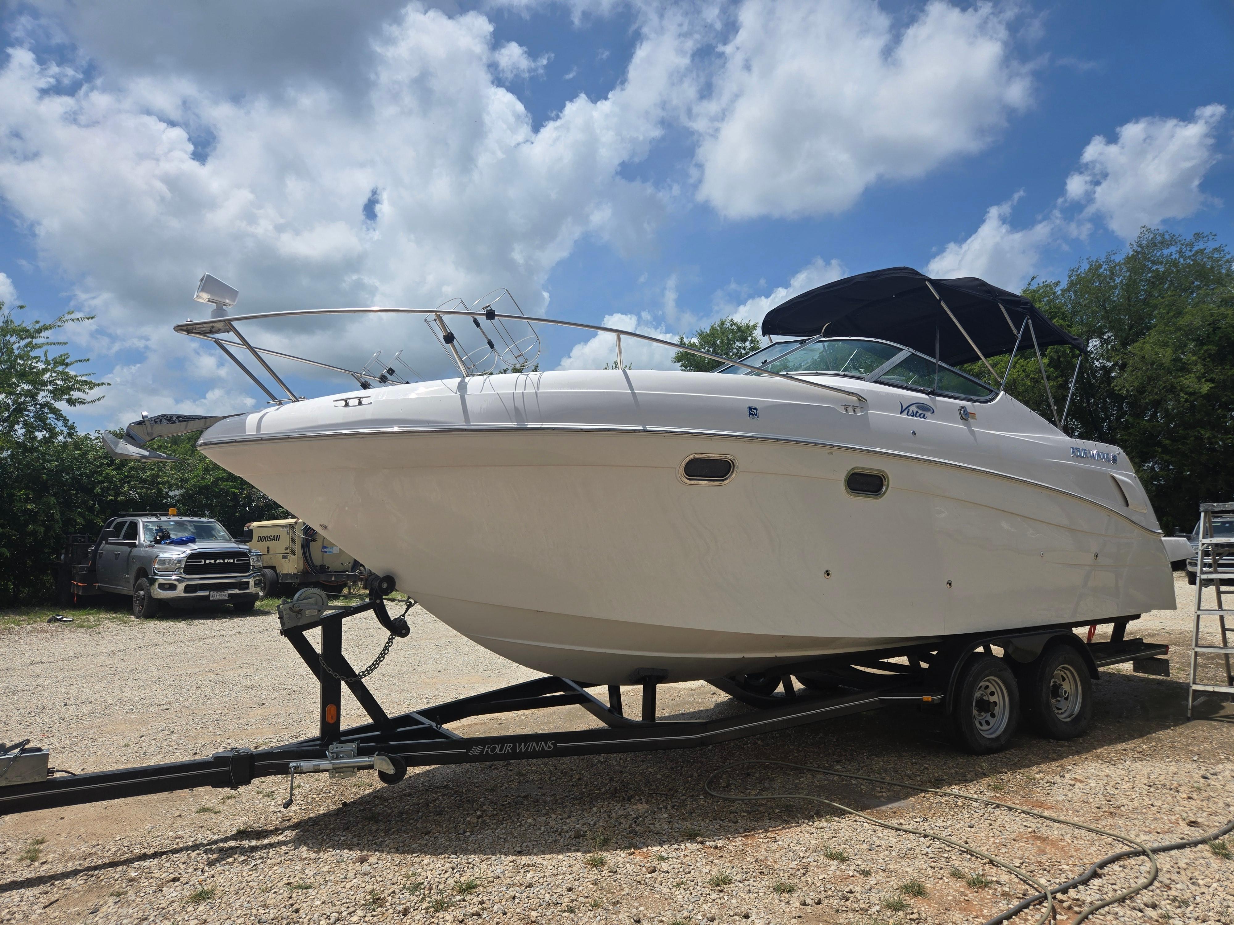 Four Winns 268 Vista 2004 Four Winns 268 Vista boat on trailer under a cloudy sky.
