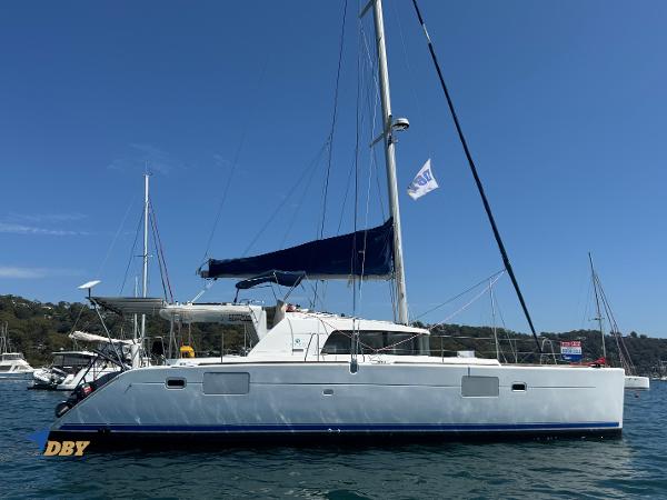 Lagoon 440 2008 Lagoon 440 catamaran with blue sail, anchored in a sunny marina.