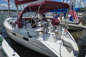 Hunter 35.5 Sailboat docked at marina, 1992 Hunter 35.5 model, featuring maroon canopy and American flag.
