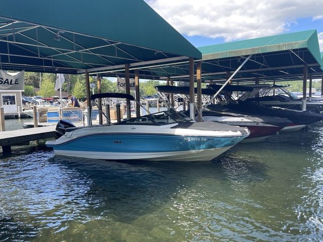 Sea Ray SPX 210 2023 Sea Ray SPX 210 boat docked under a green canopy, available for sale.