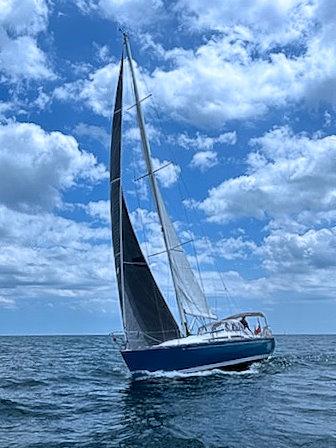 C&C 121 Sailboat C&C 121 (1999) navigating under a blue sky with clouds.