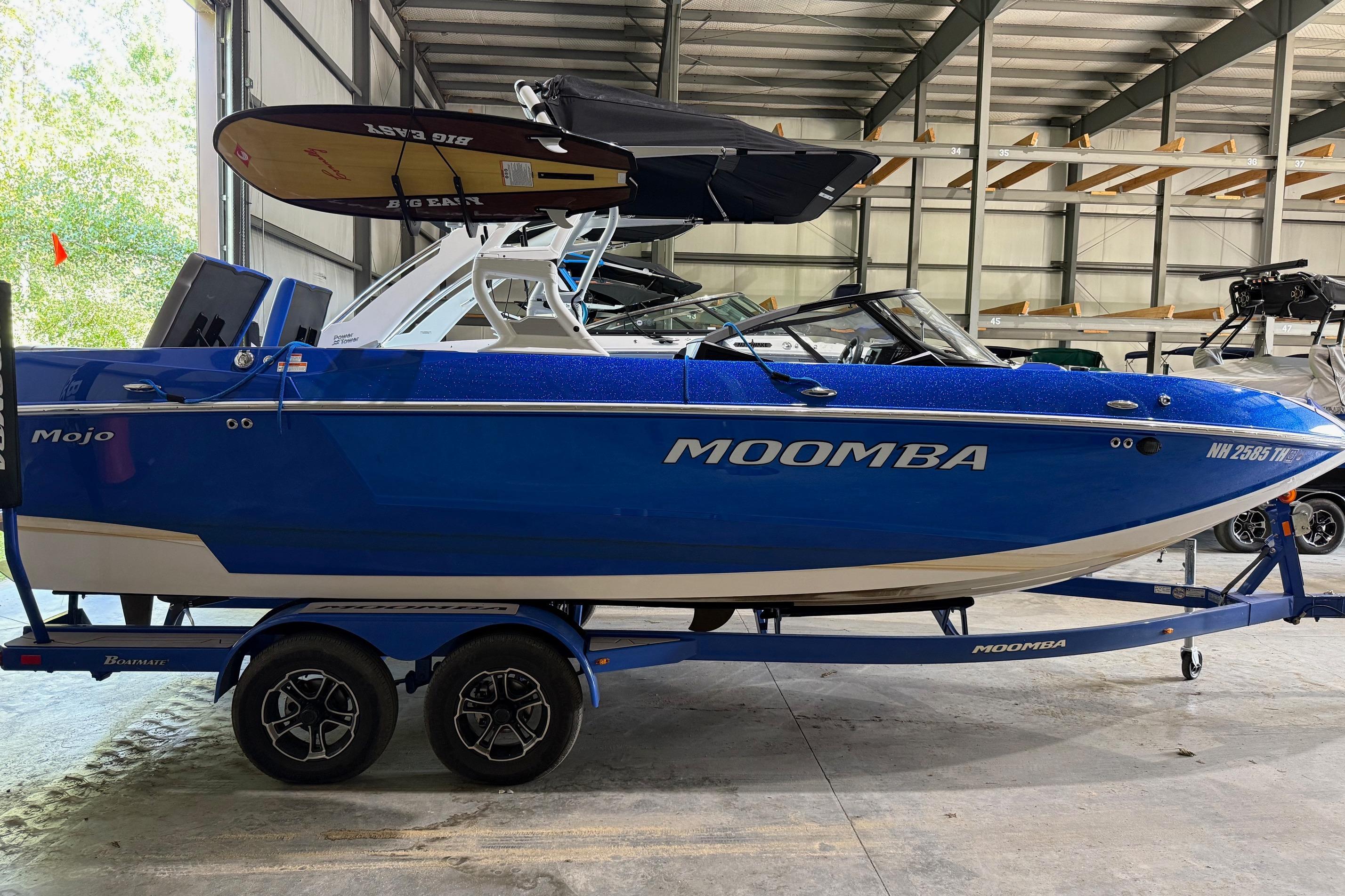 Moomba Mojo 2023 Moomba Mojo boat in blue, parked indoors on a trailer.