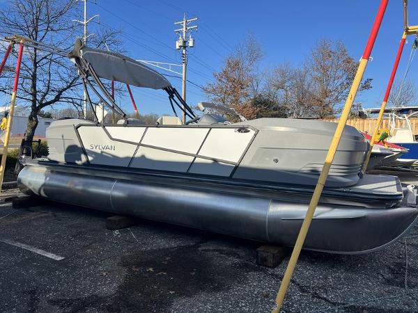 Sylvan A22 LZ DH SPORT 2025 Sylvan A22 LZ DH SPORT pontoon boat on display in a parking lot.