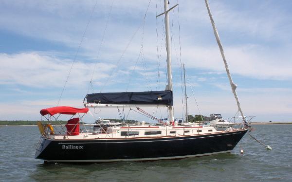Sabre 38 MK I 1986 Sabre 38 MK I sailboat with red canopy, anchored in calm waters.