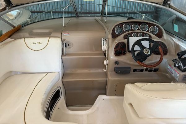 Sea Ray 280 Sundancer 2003 Sea Ray 280 Sundancer helm with gauges, steering wheel, and beige seating.