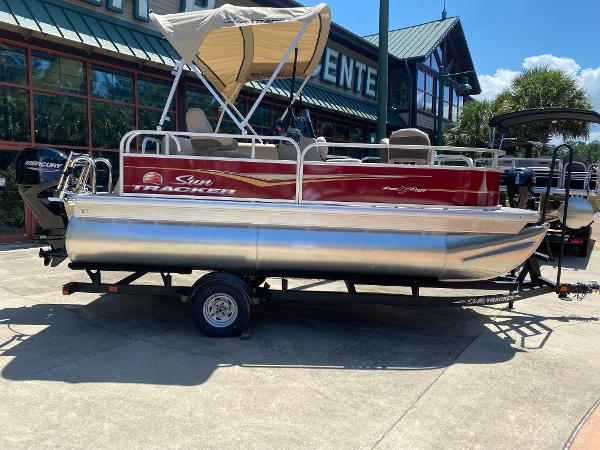 Sun Tracker Bass Buggy 16 XL Select 2025 Sun Tracker Bass Buggy 16 XL Select pontoon boat on trailer, parked outdoors.