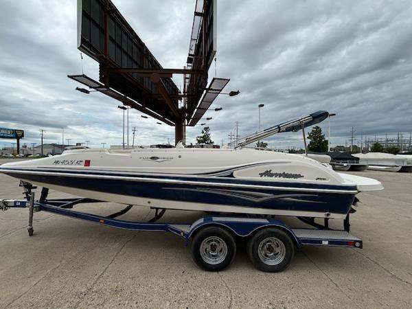 Hurricane 202FD 2007 Hurricane 202FD boat on a trailer under a cloudy sky.