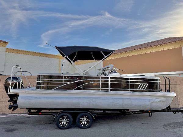 Bennington 23 LPD 2021 Bennington 23 LPD pontoon boat on trailer, parked outdoors under blue sky.