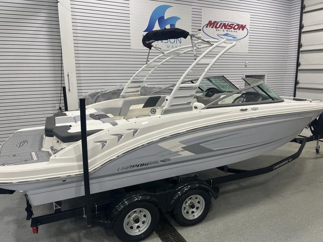 Chaparral 23 SSi 2025 Chaparral 23 SSi boat on trailer in showroom, featuring sleek design and modern features.