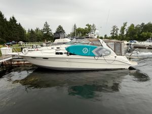 Sea Ray 330 Sundancer 1996 Sea Ray 330 Sundancer yacht docked with paddleboard on deck, surrounded by trees and water.