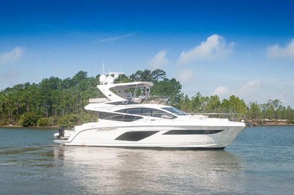 Sea Ray L550 FLYBRIDGE 2018 Sea Ray L550 Flybridge yacht cruising on a serene lake with forested background.