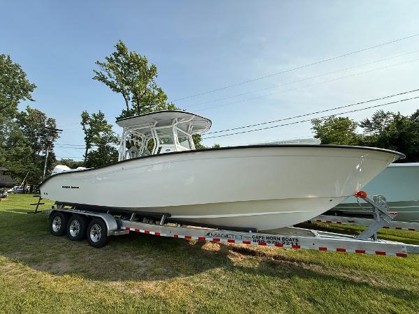 Cape Horn 32 XS 2025 Cape Horn 32 XS boat on trailer, parked on grass, side view.
