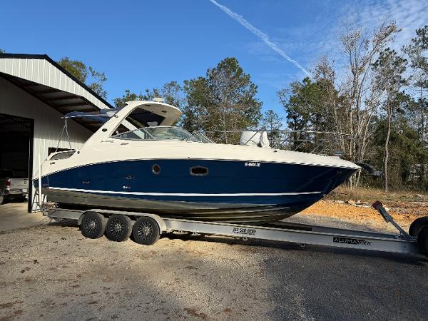 Sea Ray 310 Sundancer 2012 Sea Ray 310 Sundancer boat on trailer near a storage building.