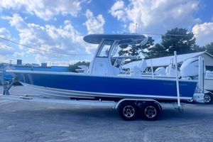 Sportsman Masters 247OE Bay Boat 2022 Sportsman Masters 247OE Bay Boat on trailer, blue hull, clear sky background.