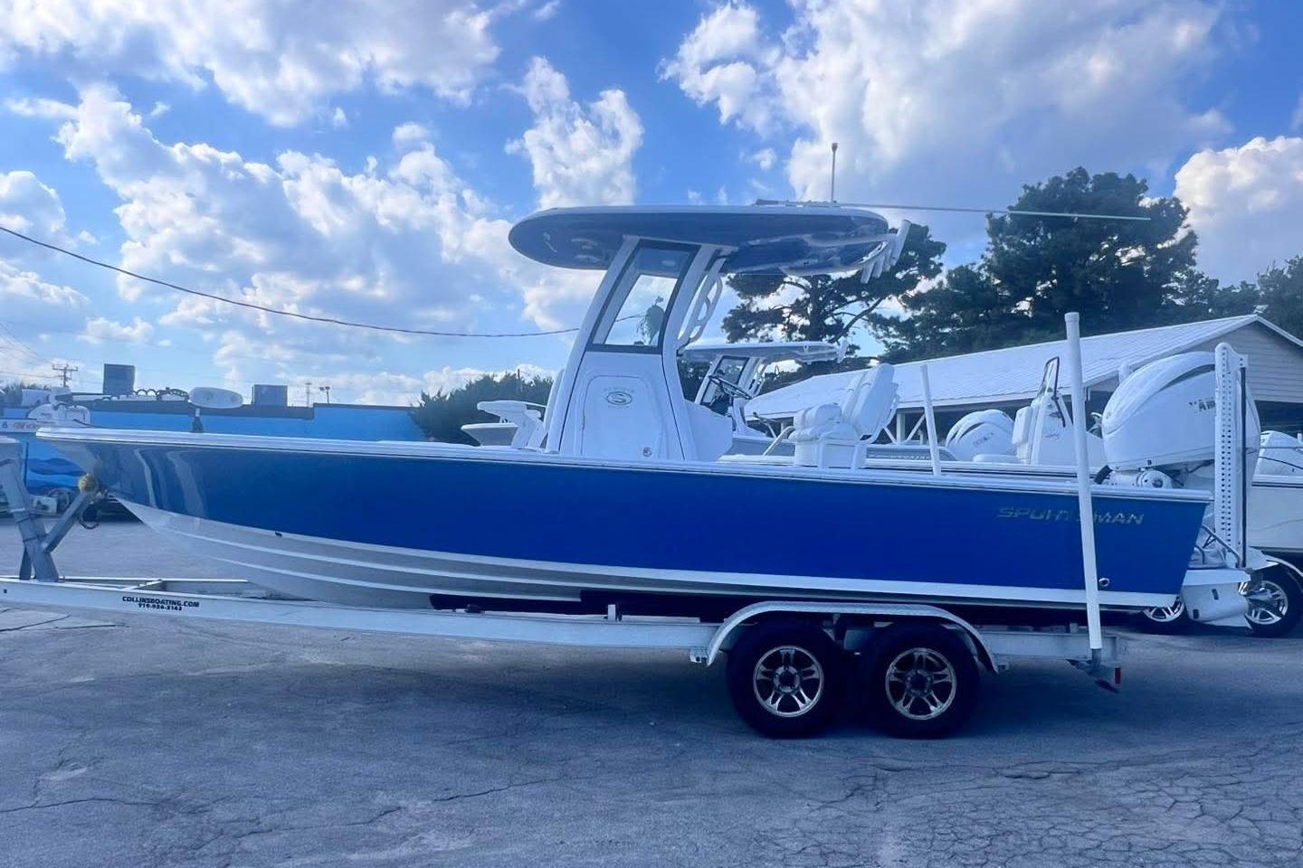 Sportsman Masters 247OE Bay Boat 2022 Sportsman Masters 247OE Bay Boat on trailer, blue hull, clear sky background.