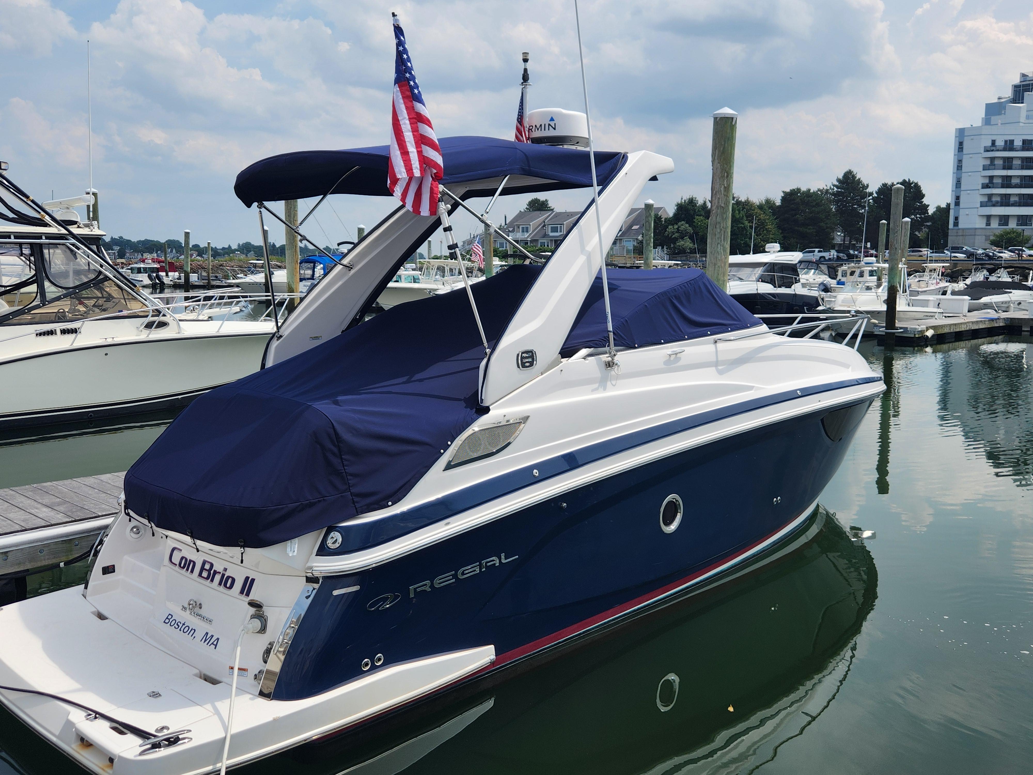 Regal 28 Express 2019 Regal 28 Express boat docked at marina with American flag.