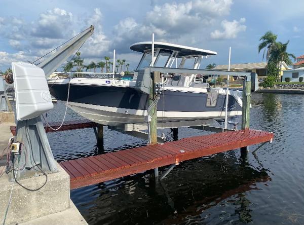 Robalo R272 Center Console 2021 Robalo R272 Center Console boat docked on a lift by the water.