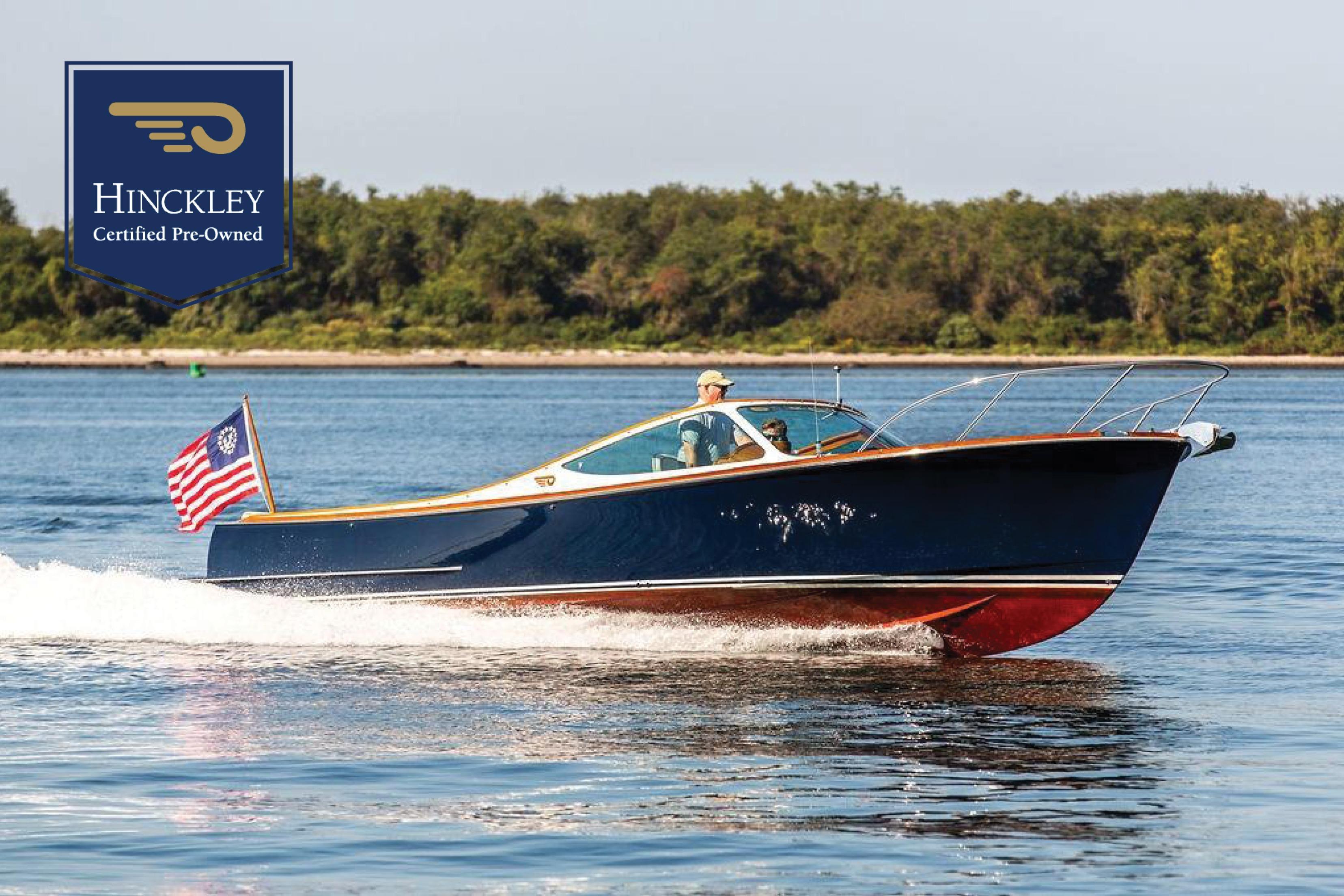 Hinckley T29R 2003 Hinckley T29R boat cruising on water, certified pre-owned, with American flag.