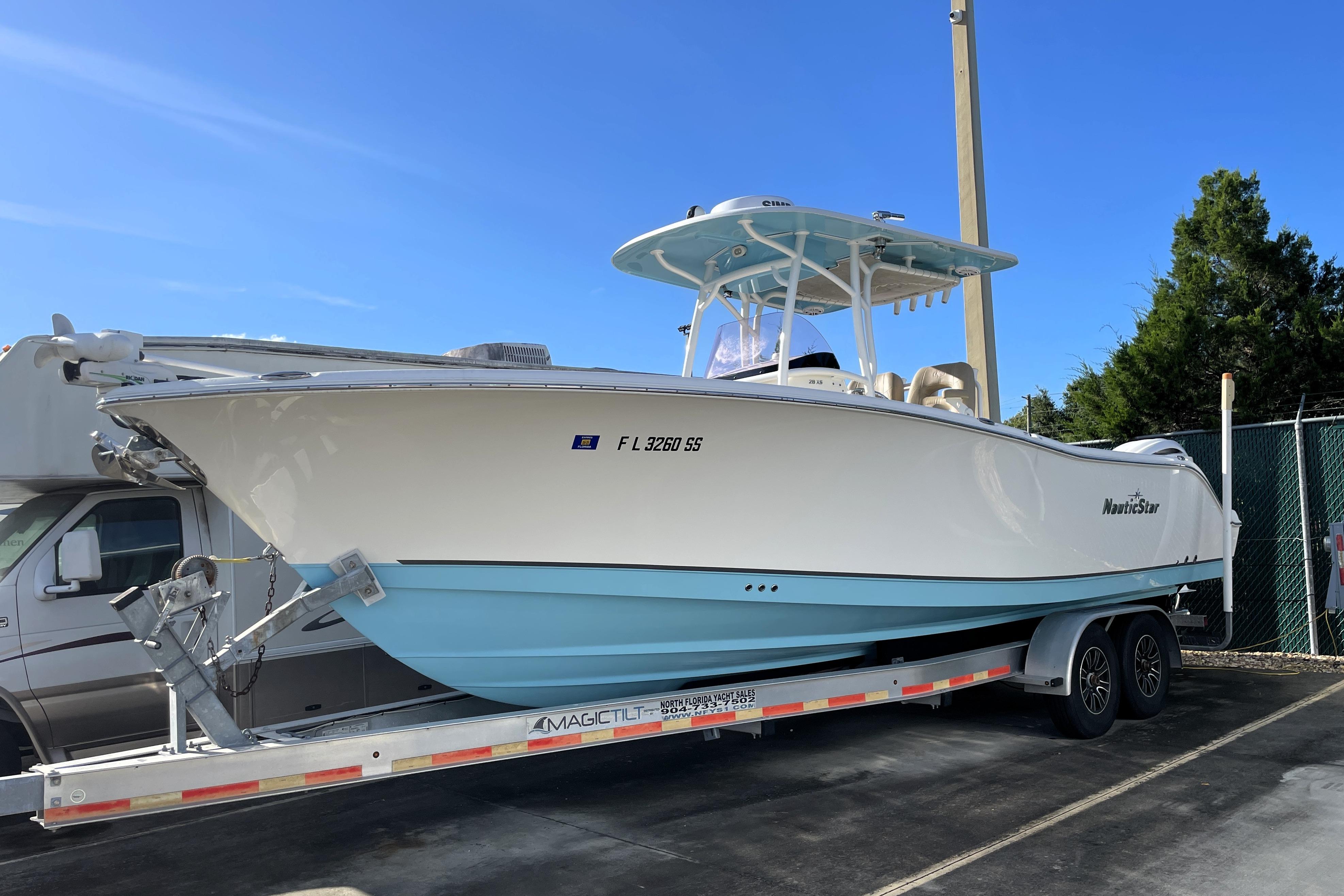 NauticStar 28 XS 2020 NauticStar 28 XS boat on trailer, white and blue, parked outdoors.