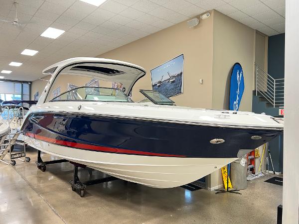 Sea Ray SLX 310 2025 Sea Ray SLX 310 boat displayed indoors, featuring sleek design and modern amenities.