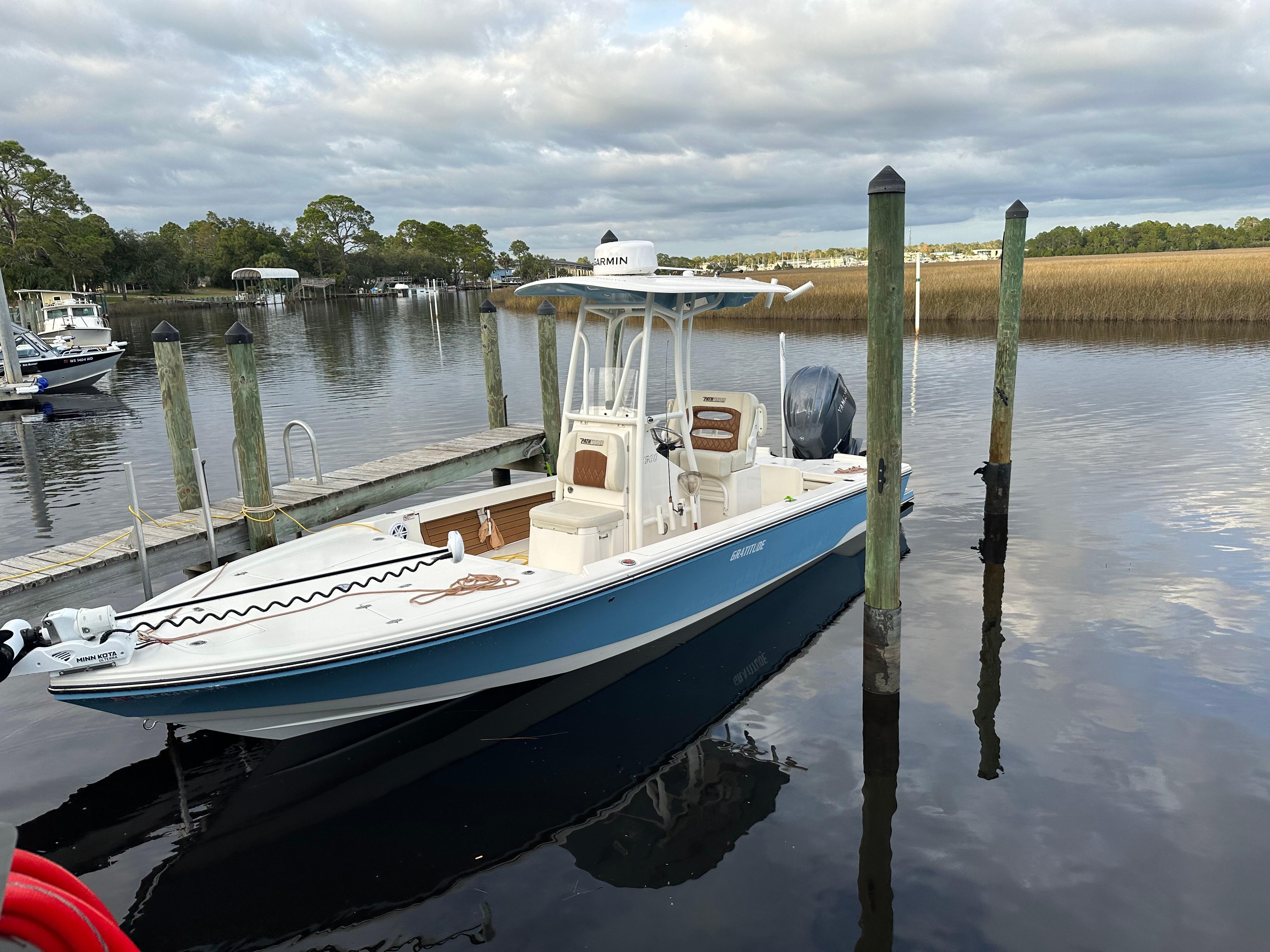 Pathfinder 2500 Hybrid 2023 Pathfinder 2500 Hybrid boat docked on a calm lake under cloudy skies.