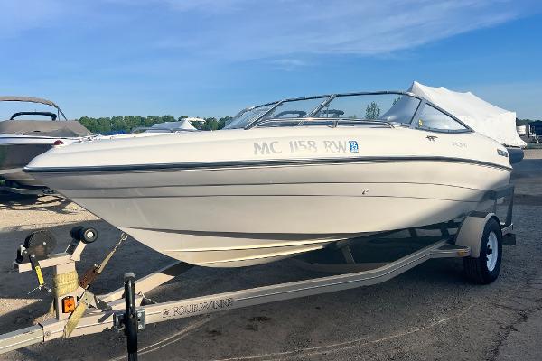 Four Winns 180 Horizon 1999 Four Winns 180 Horizon boat on trailer, parked outdoors.