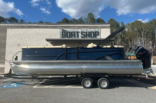 Crest Classic Platinum 240SLC 2024 Crest Classic Platinum 240SLC pontoon boat parked outside a boat shop.