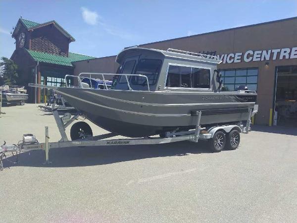 Spartan 220 Maximus Pro 2024 Spartan 220 Maximus Pro boat on a trailer outside a service center.