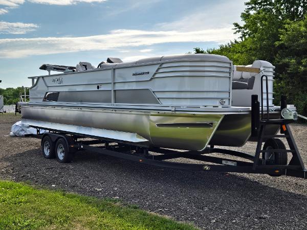 SunCatcher Elite 326 SL 2024 SunCatcher Elite 326 SL pontoon boat on trailer, parked outdoors.