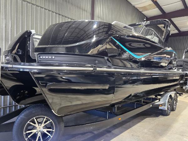 SunCatcher Amara 2024 SunCatcher Amara boat in a showroom, sleek black design on a trailer.