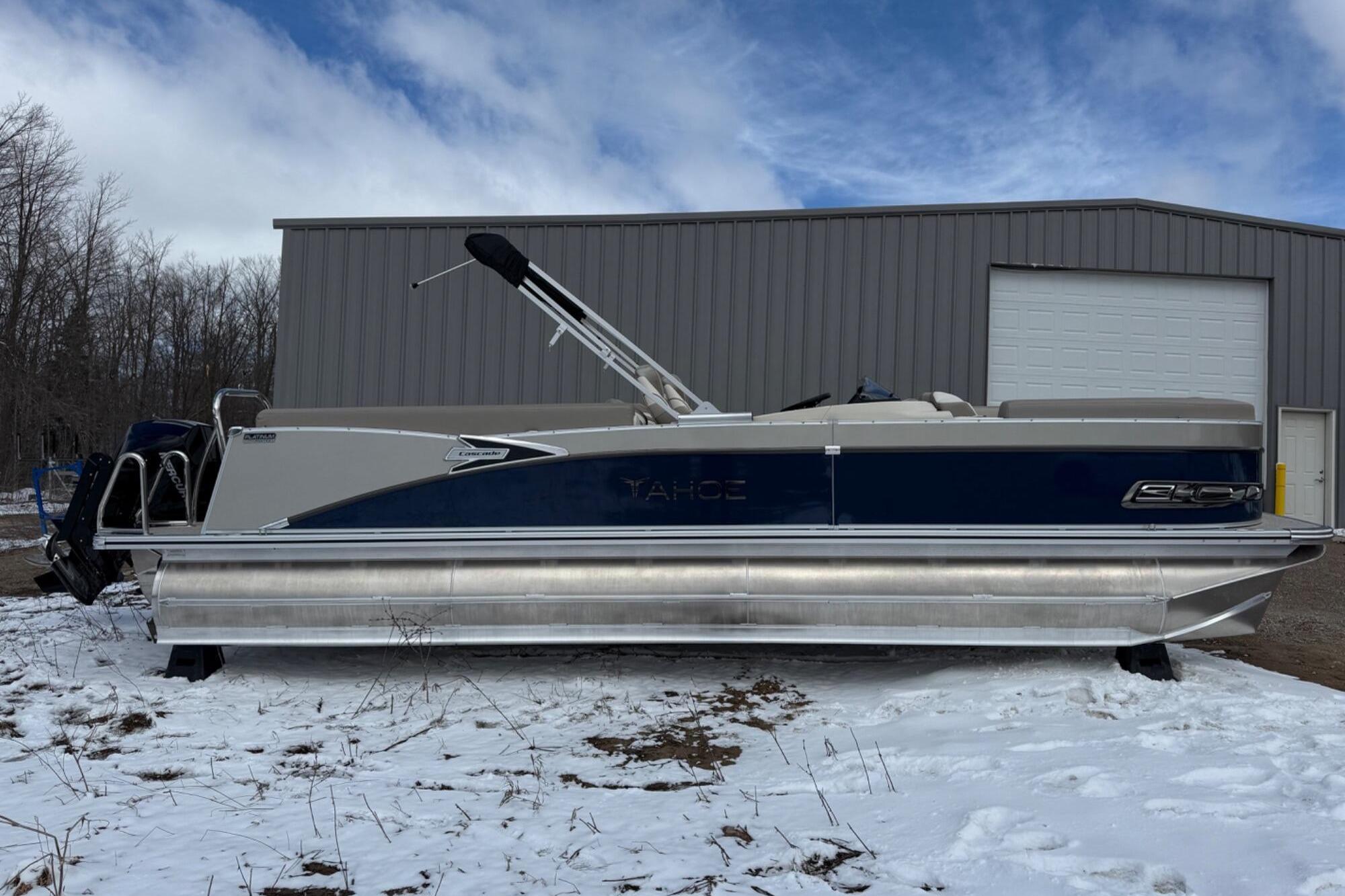 Tahoe 2585 2025 Tahoe 2585 pontoon boat parked on snowy ground near a metal building.