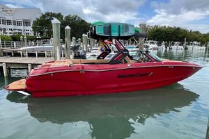 MasterCraft X24 2025 MasterCraft X24 boat in vibrant red docked at a marina.