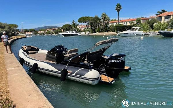 Master 855 A 2023 Master 855 boat with Suzuki engine docked in a scenic canal.