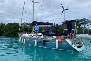 Jeanneau Sun Odyssey 42i 2008 Jeanneau Sun Odyssey 42i sailboat anchored in turquoise water with a person on deck.