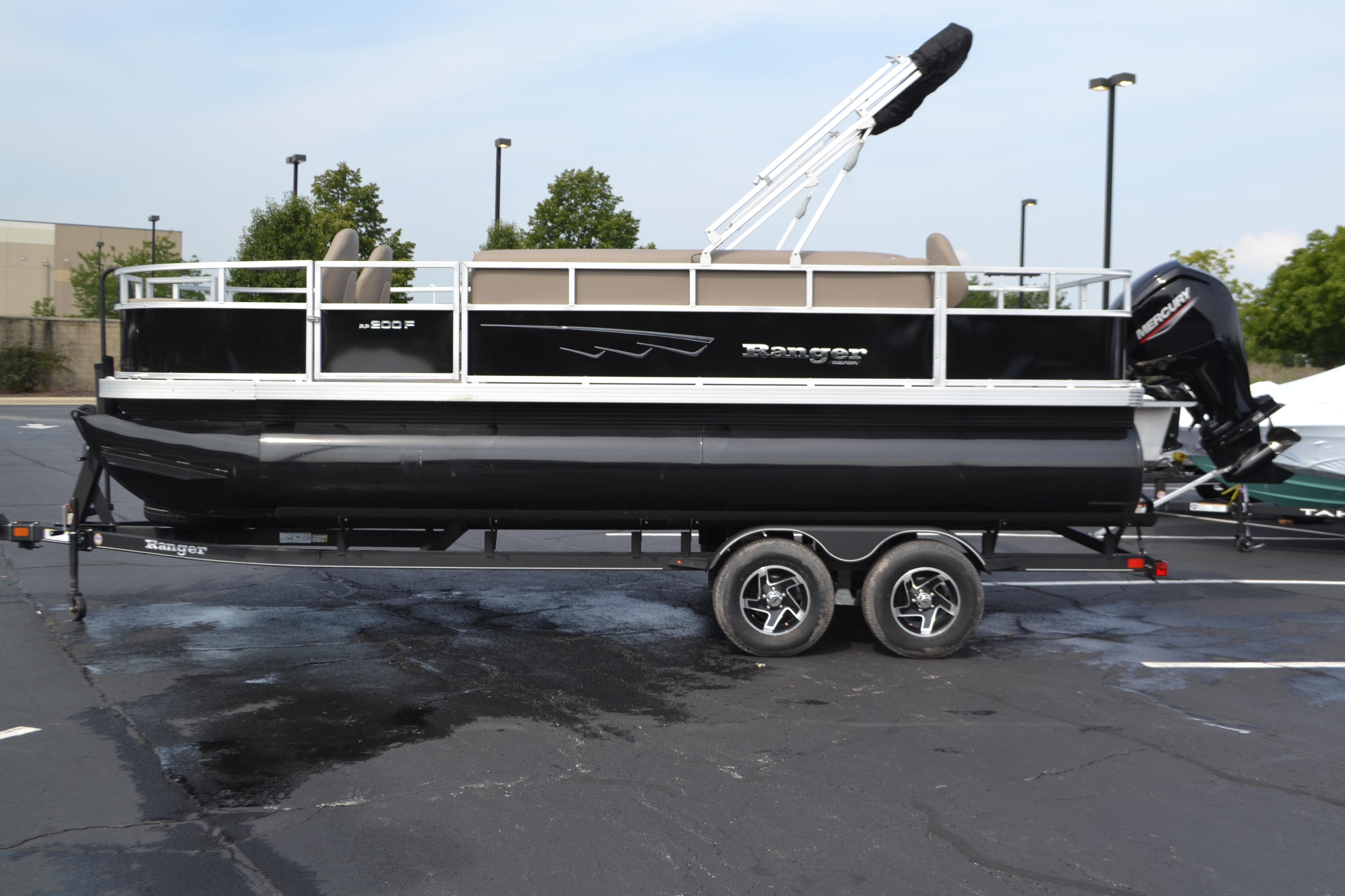 Ranger Reata 200F 2024 Ranger Reata 200F pontoon boat on trailer in parking lot.