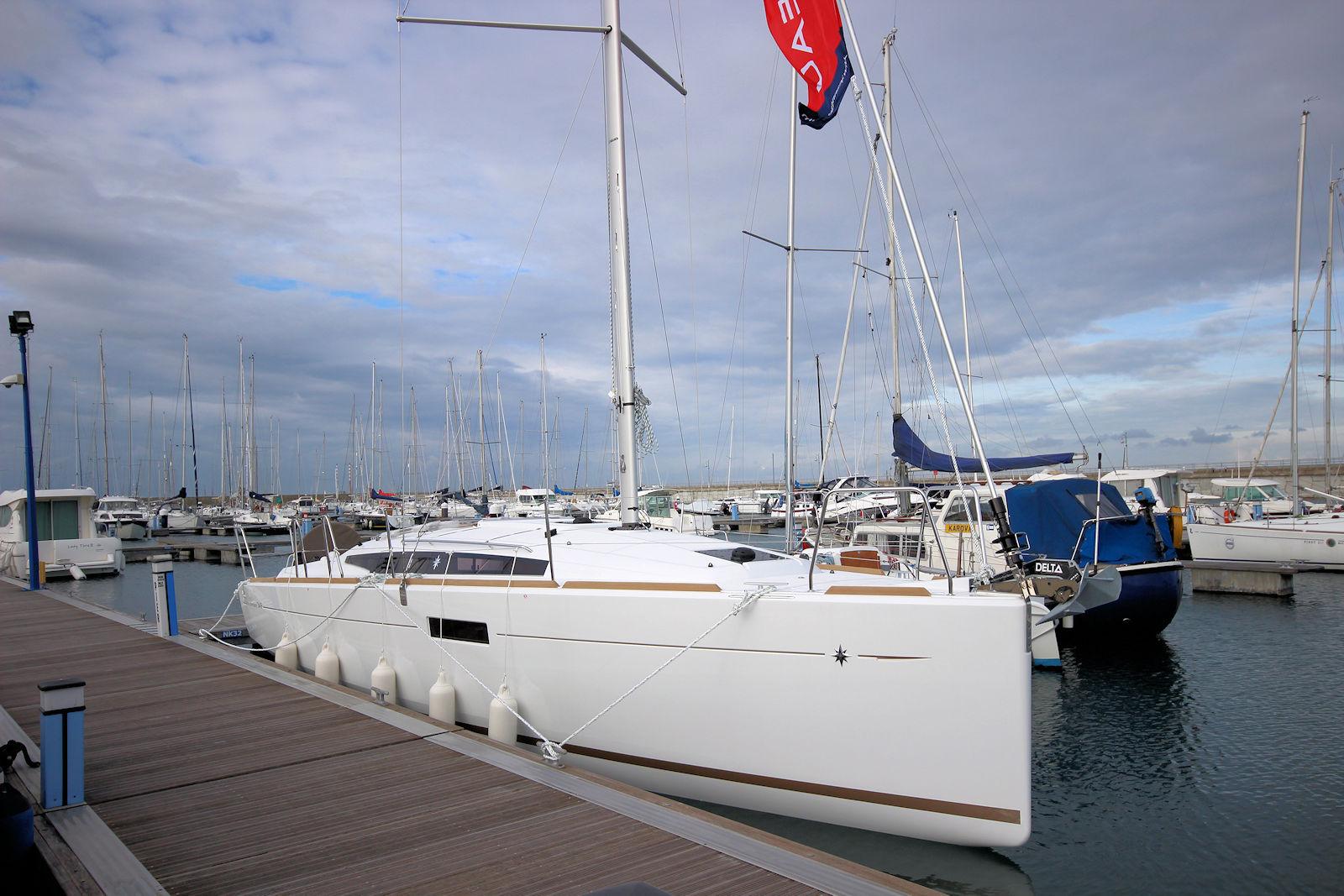 Jeanneau Sun Odyssey 349 2019 Jeanneau Sun Odyssey 349 sailboat docked in a marina under cloudy skies.