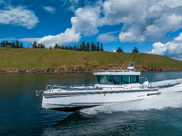 Axopar 28 2022 Axopar 28 boat cruising on a scenic lake under a blue sky.