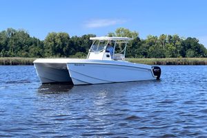 Aquila 28 Molokai Aquila 28 Molokai 2021 catamaran on calm water with lush green shoreline.