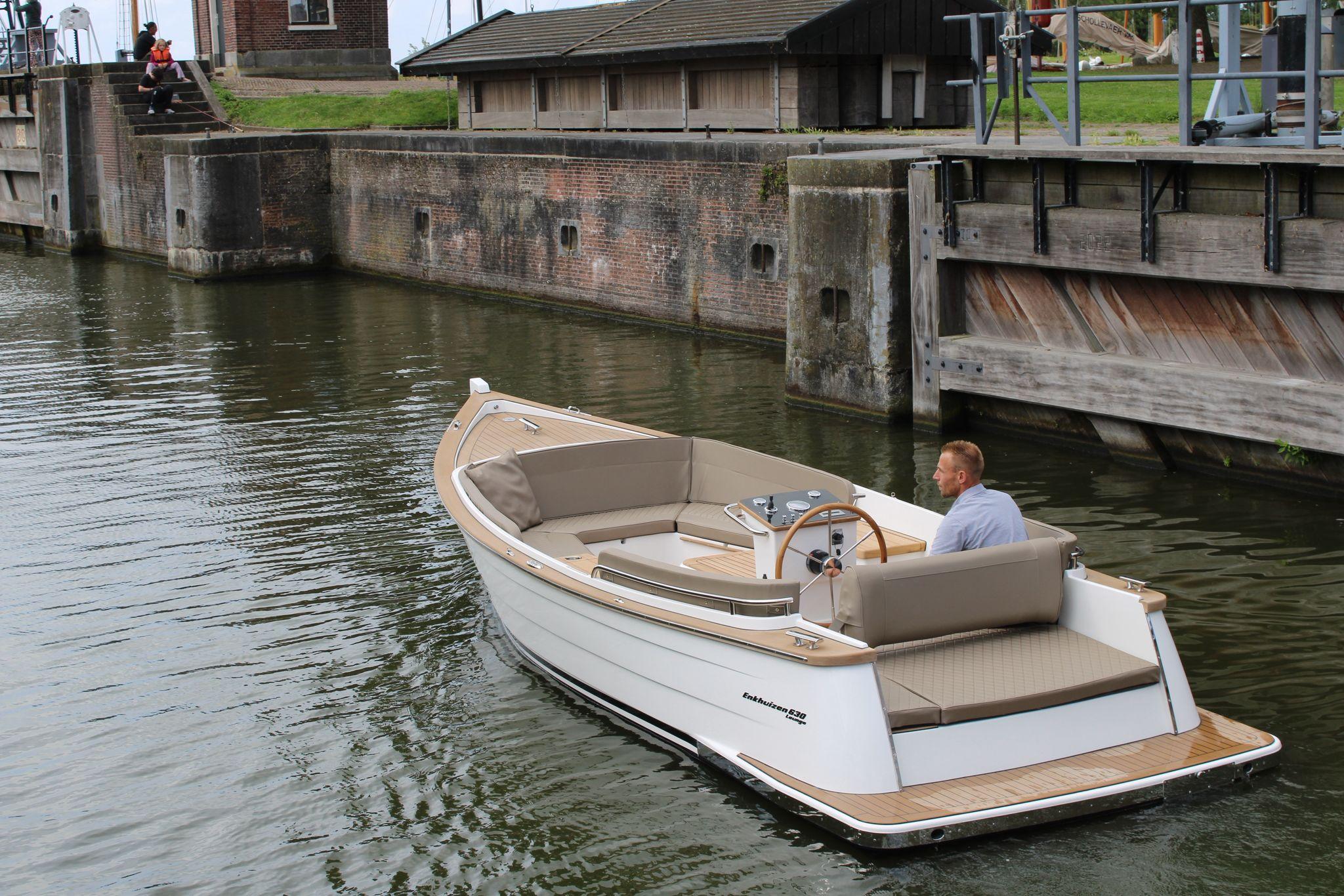 Enkhuizensloep Enkhuizen 630 lounge 2025 Enkhuizensloep Enkhuizen 630 lounge boat navigating a canal near a brick structure.
