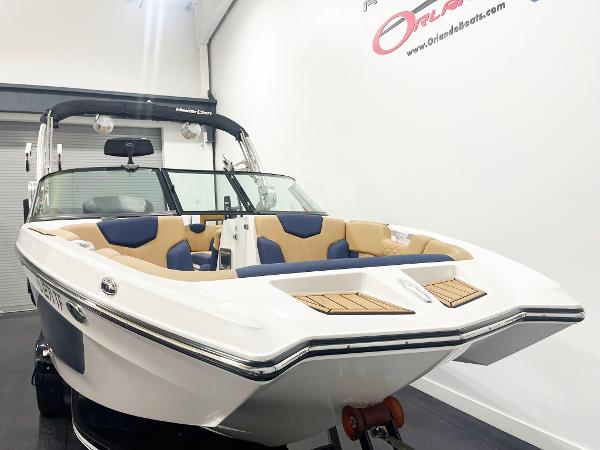 MasterCraft NXT24 2022 MasterCraft NXT24 boat with sleek design and spacious seating in showroom.