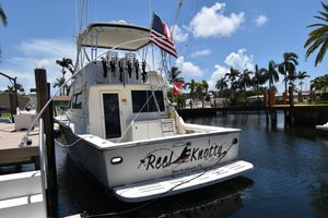 Tiara Yachts 4300 1997 Tiara 4300 yacht docked in sunny marina with palm trees and flags.