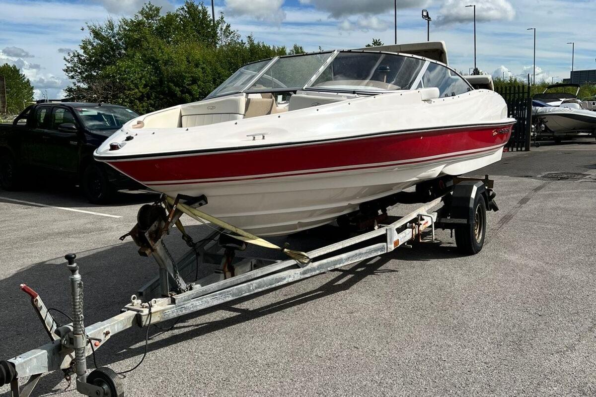 Regal 1800 Bowrider 2004 Regal 1800 Bowrider boat on trailer in parking lot.