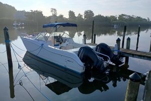 World Cat 246 DC 2000 World Cat 246 DC boat docked with dual Mercury engines, calm water backdrop.