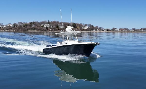 Edgewater 318CC 2009 Edgewater 318CC boat cruising on calm water near a coastal landscape.