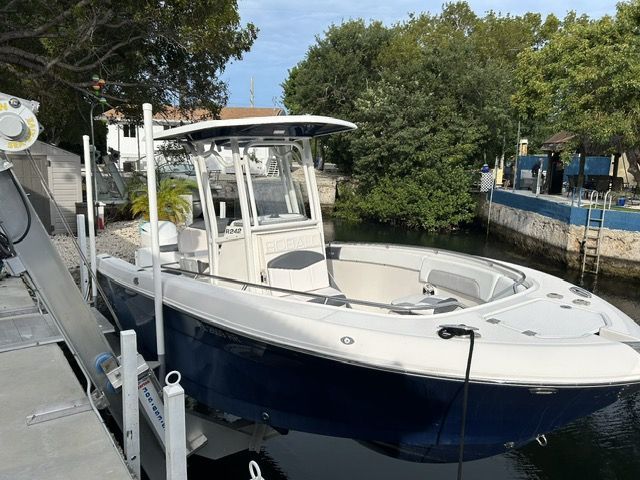 Robalo R242 2018 Robalo R242 boat docked near lush greenery and calm waters.