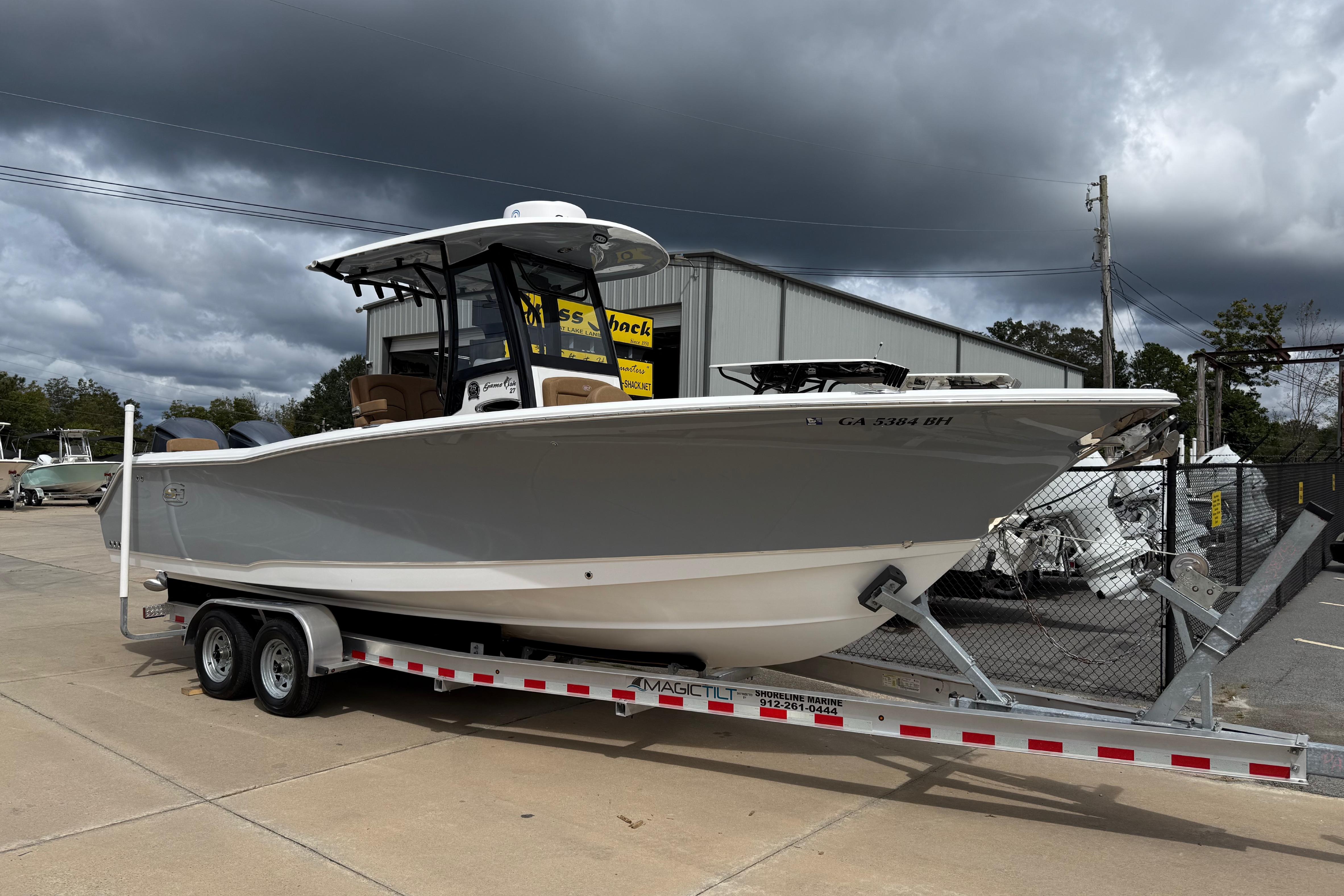 Sea Hunt Gamefish 27 Forward Seating 2021 Sea Hunt Gamefish 27 boat on trailer, parked outdoors under cloudy sky.